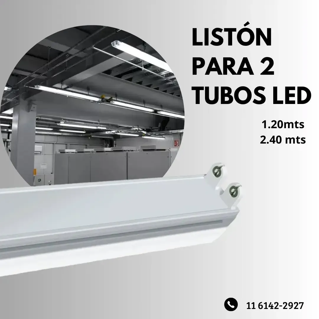 Luminaria LED blanca de tubo, frente a un entorno industrial borroso. 