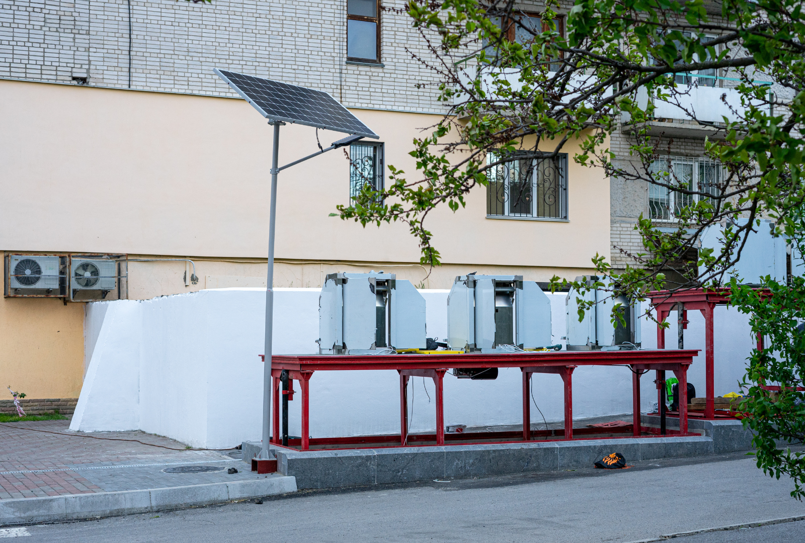 A table with a solar panel on top of it in front of a building.