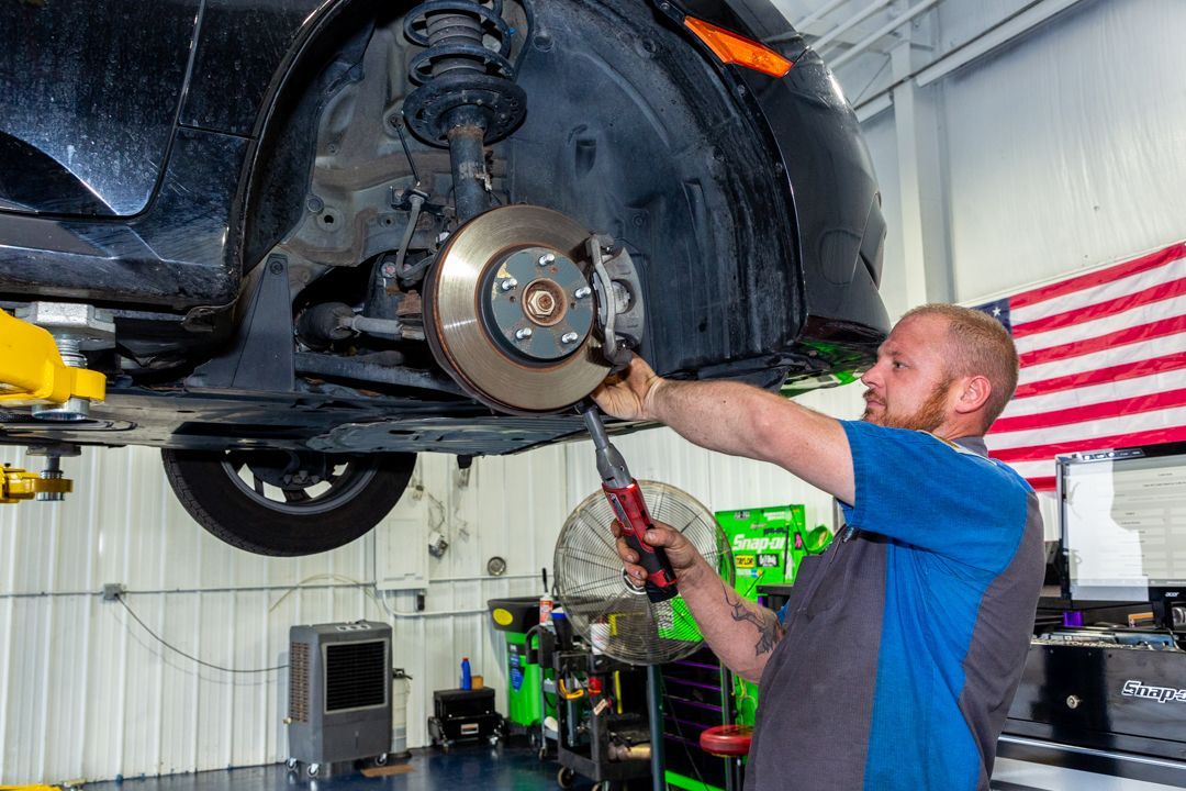 A man is working on a car in a garage.