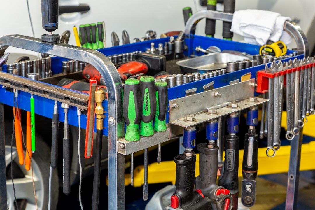 A cart filled with lots of tools in a garage.