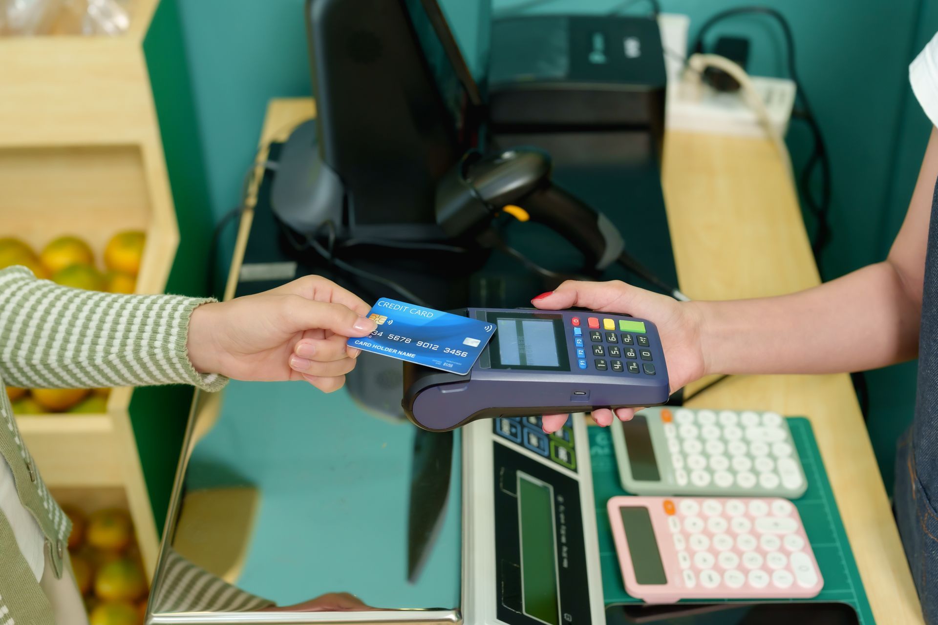 Credit card being handed over to payment terminal during transaction at local business