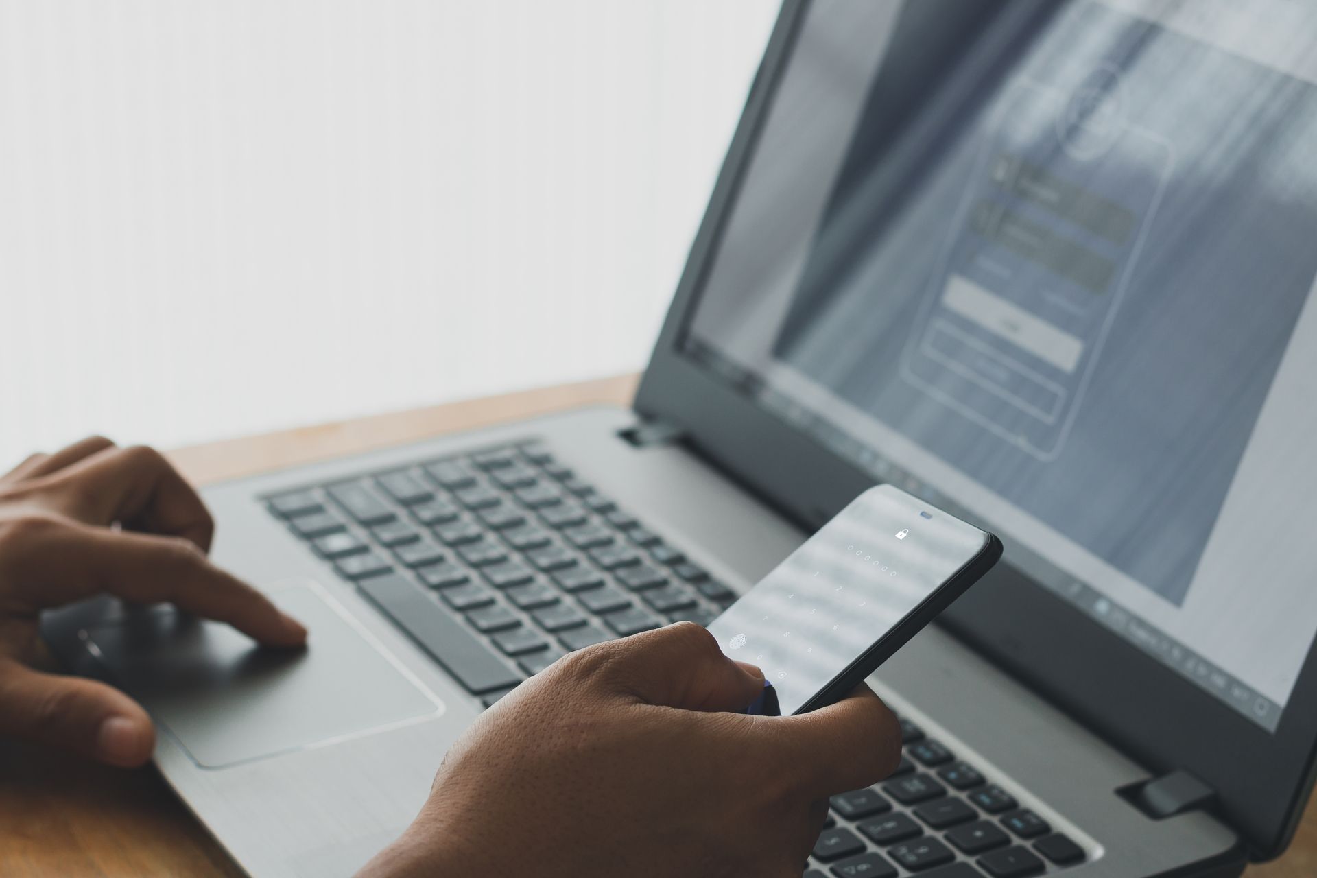 Person accessing digital assets using two-factor authentication on a smartphone and laptop