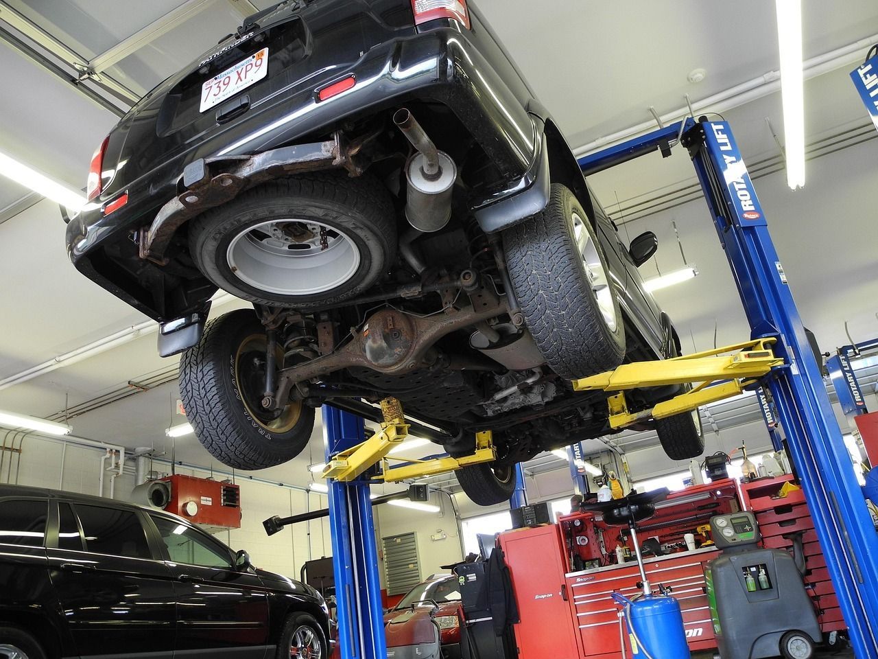 Car lifted in an auto repair shop, representing GMB categories for auto repair businesses.