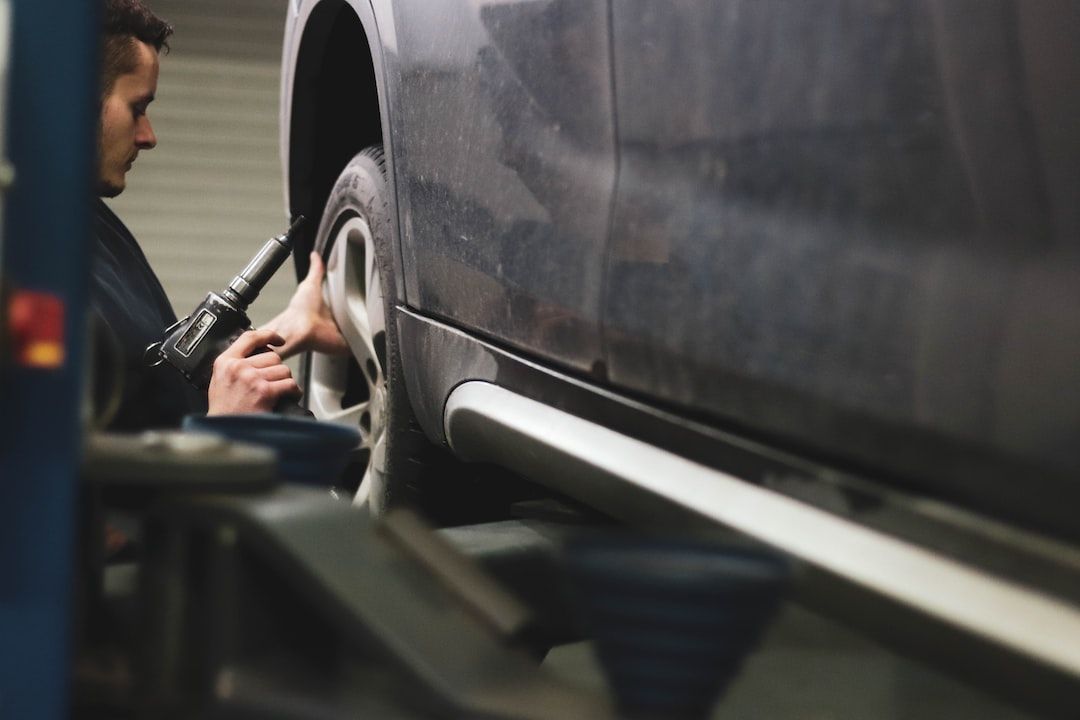 Technician with a power tool on a car tire highlighting effective auto repair shop marketing