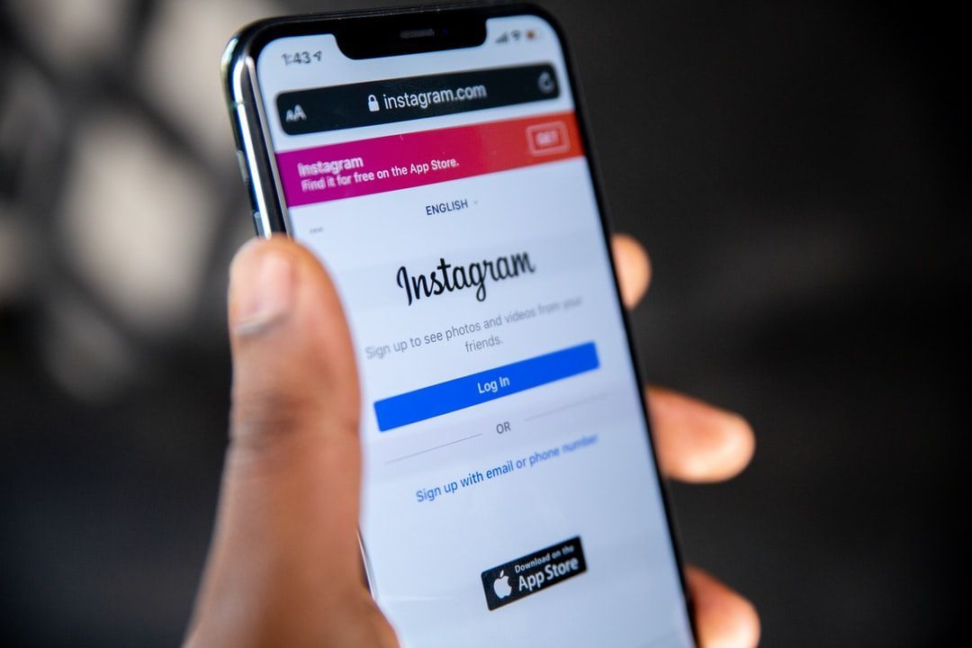 Holding a phone with the screen to the Instagram login page prompting to the instagram algorithm