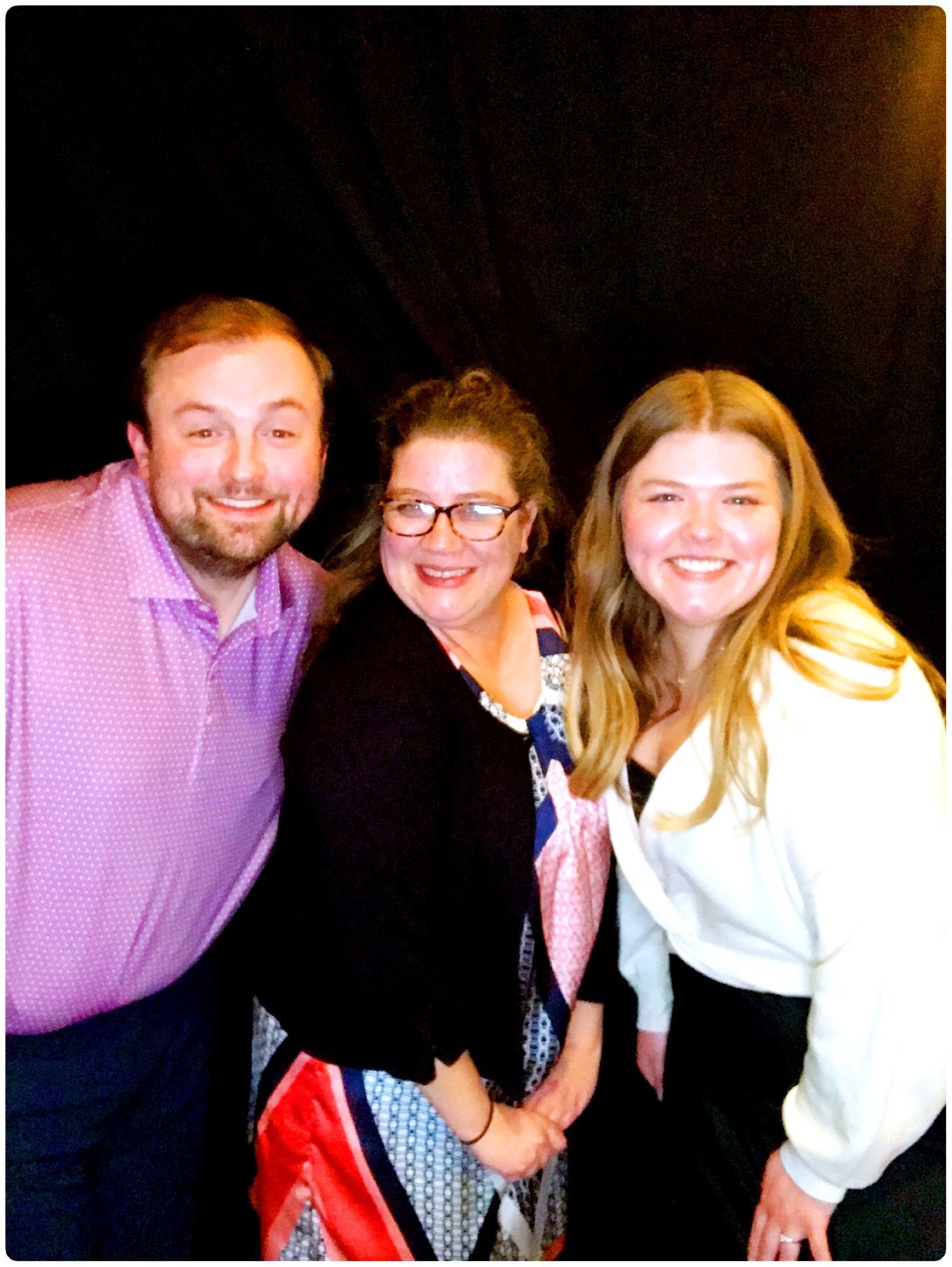 A man and two women are posing for a picture together