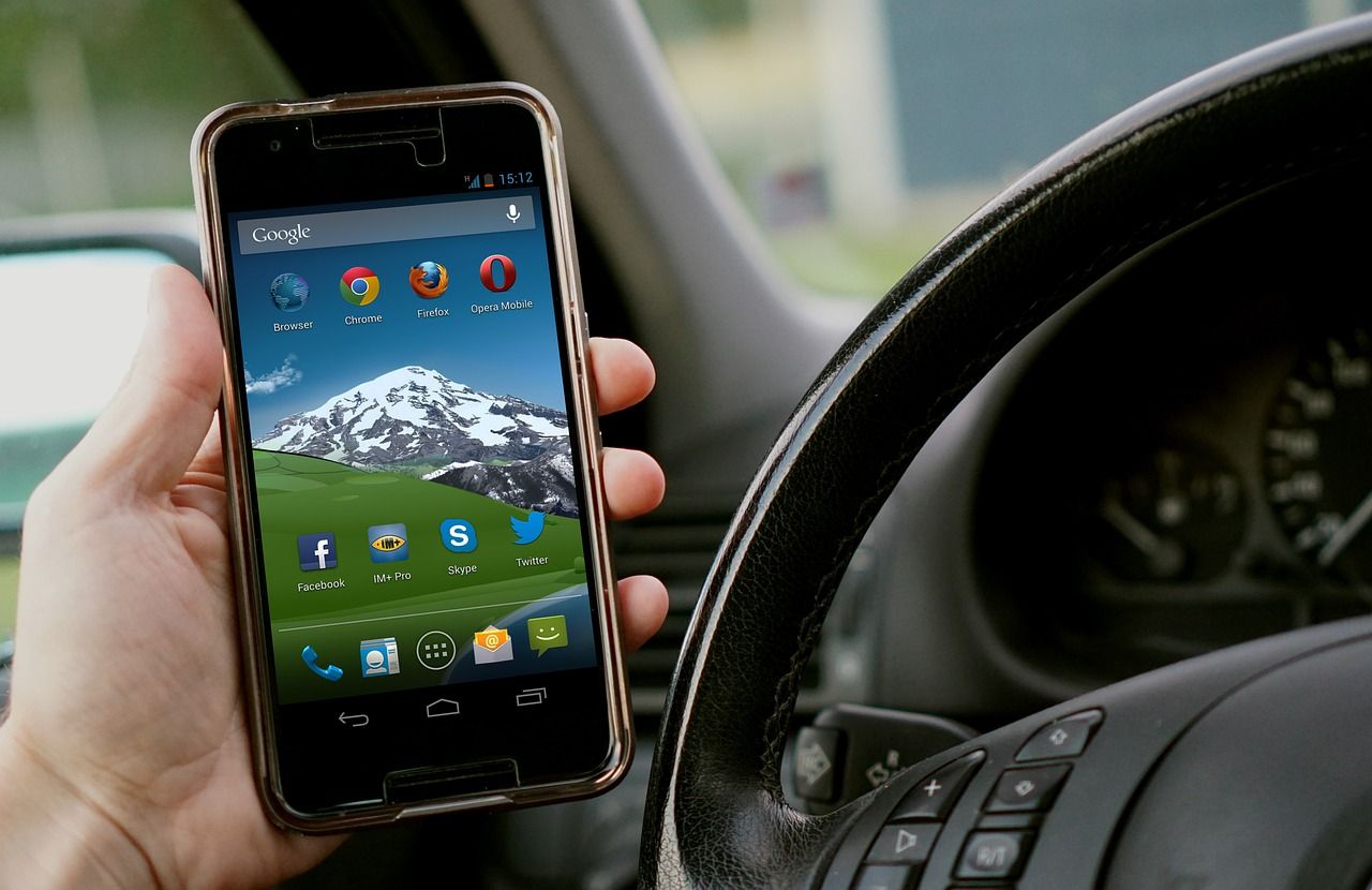 Smartphone with social media apps inside a car, reflecting an automotive social media strategy.
