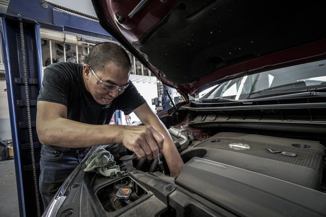 A mechanic repairs an engine, supporting auto repair customer engagement.