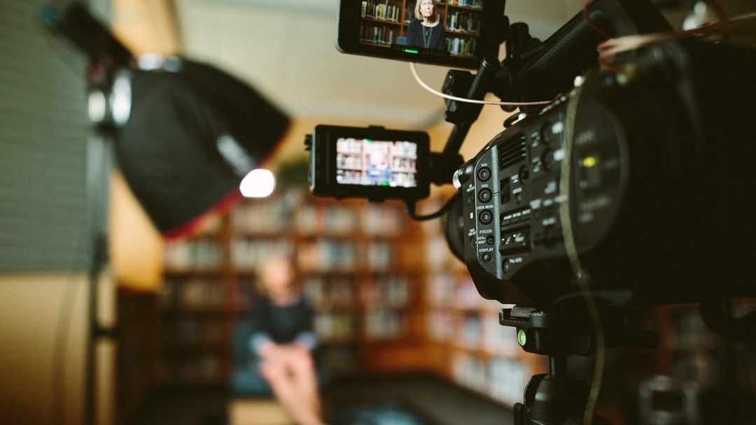 A camera records a customer testimonial video in a library.