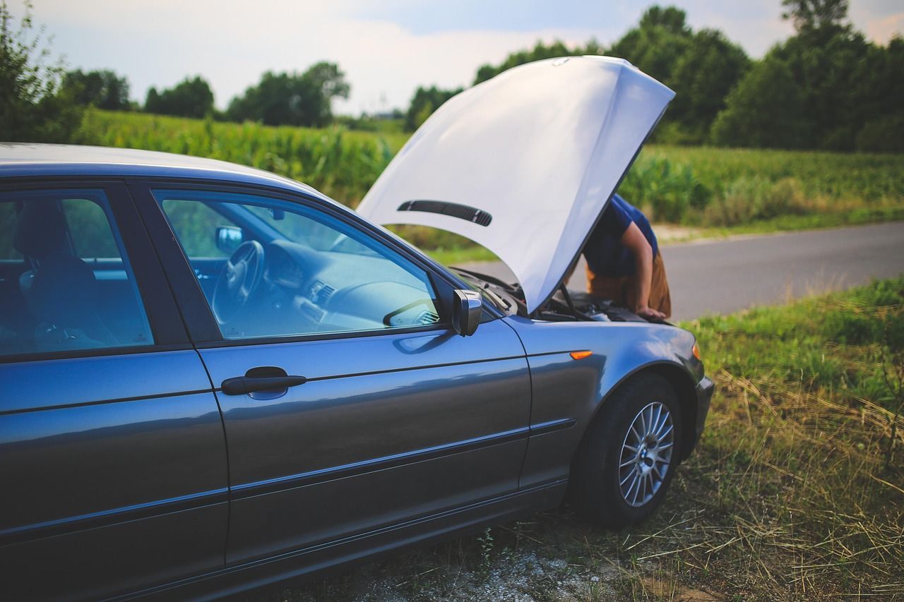 SEO for roadside assistance image showing a broken-down car with the hood open on a rural roadside