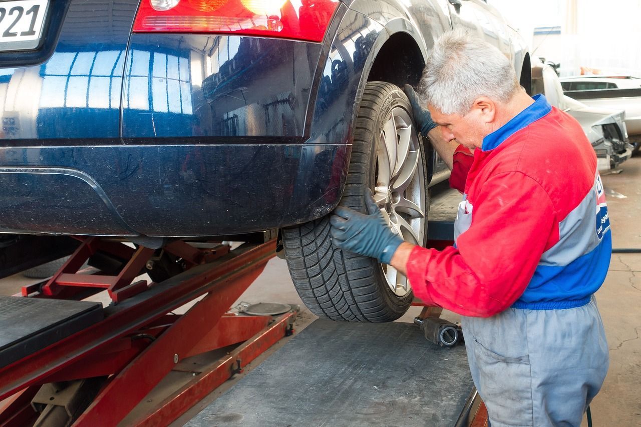 Mechanic installing a tire in garage, representing tire shop advertising ideas