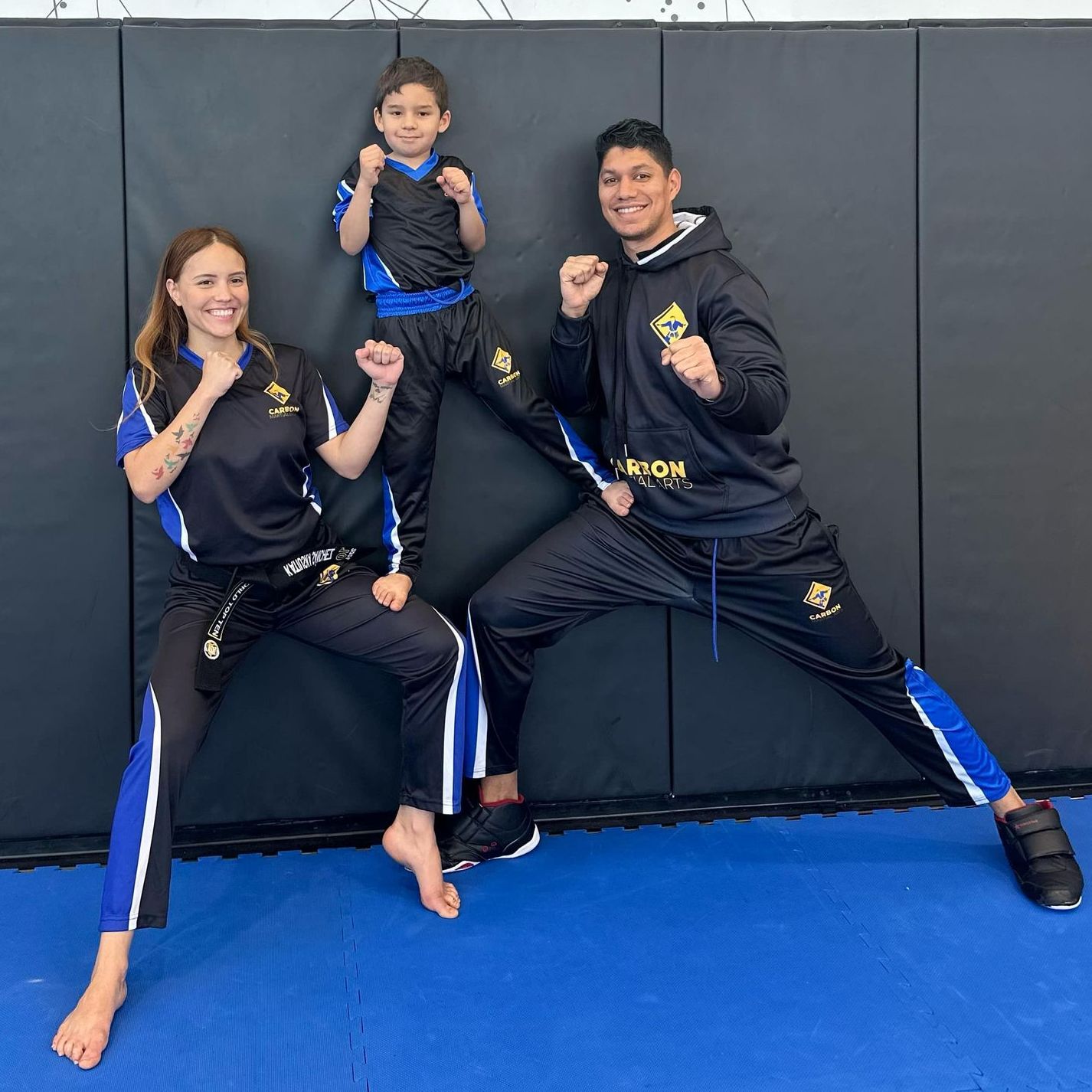 A group of young children in karate uniforms are posing for a picture.