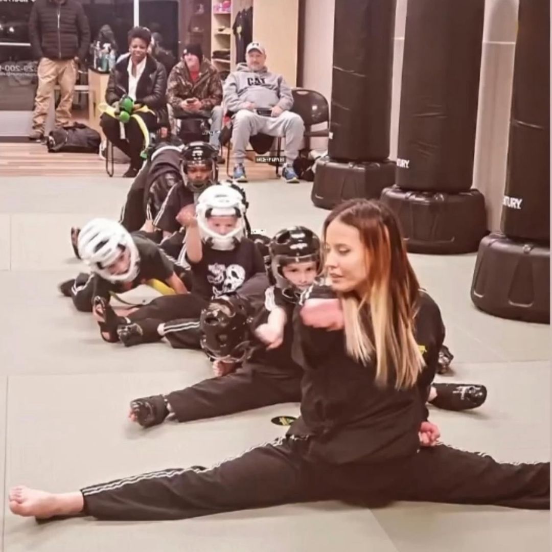 A man and a woman are practicing karate in a gym.