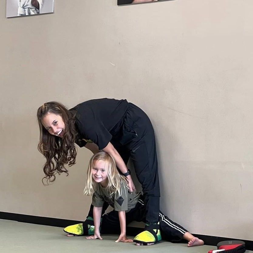 A group of young girls are practicing karate in a gym.