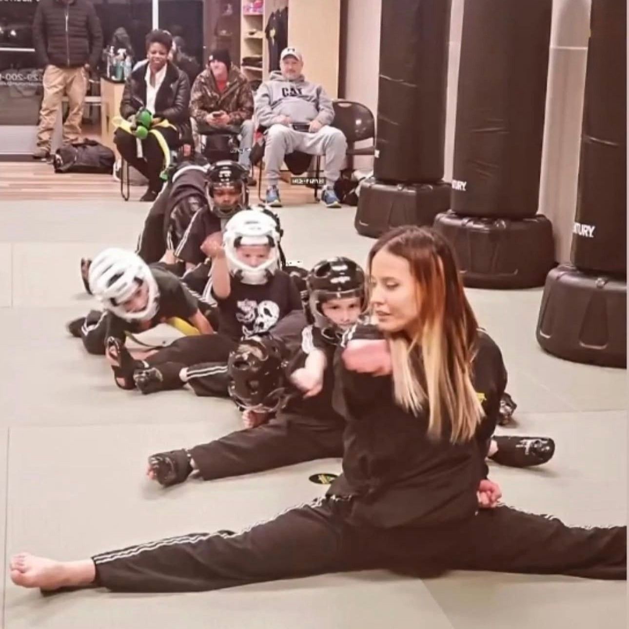 A man and a woman are practicing karate in a gym.