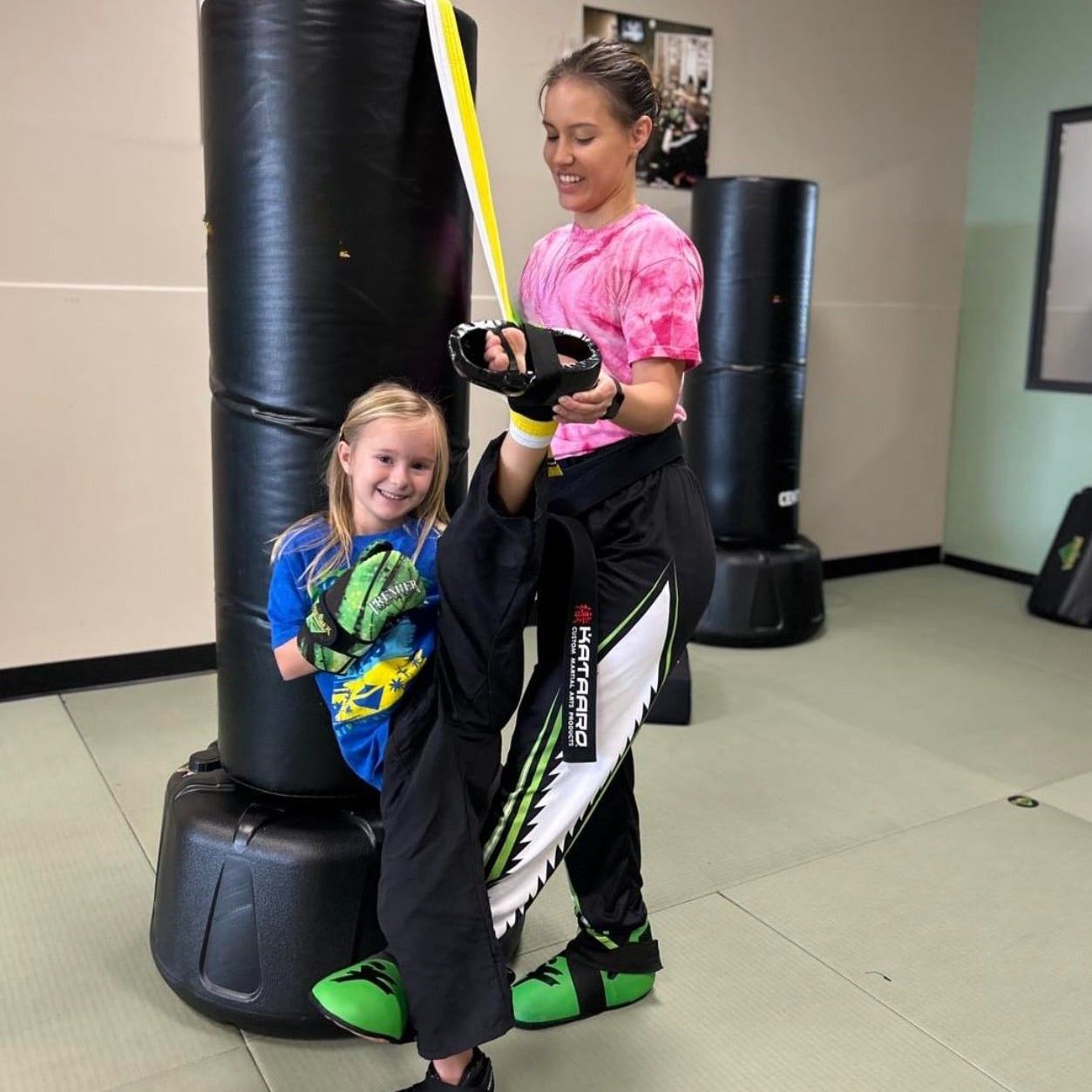 A young girl is practicing taekwondo in a gym.