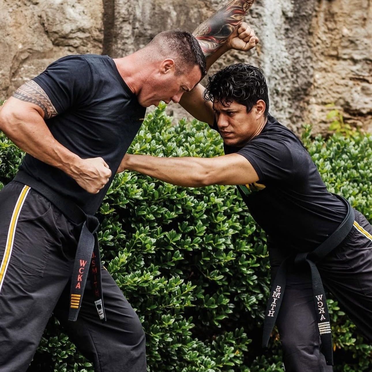 A group of men are practicing karate in a gym.