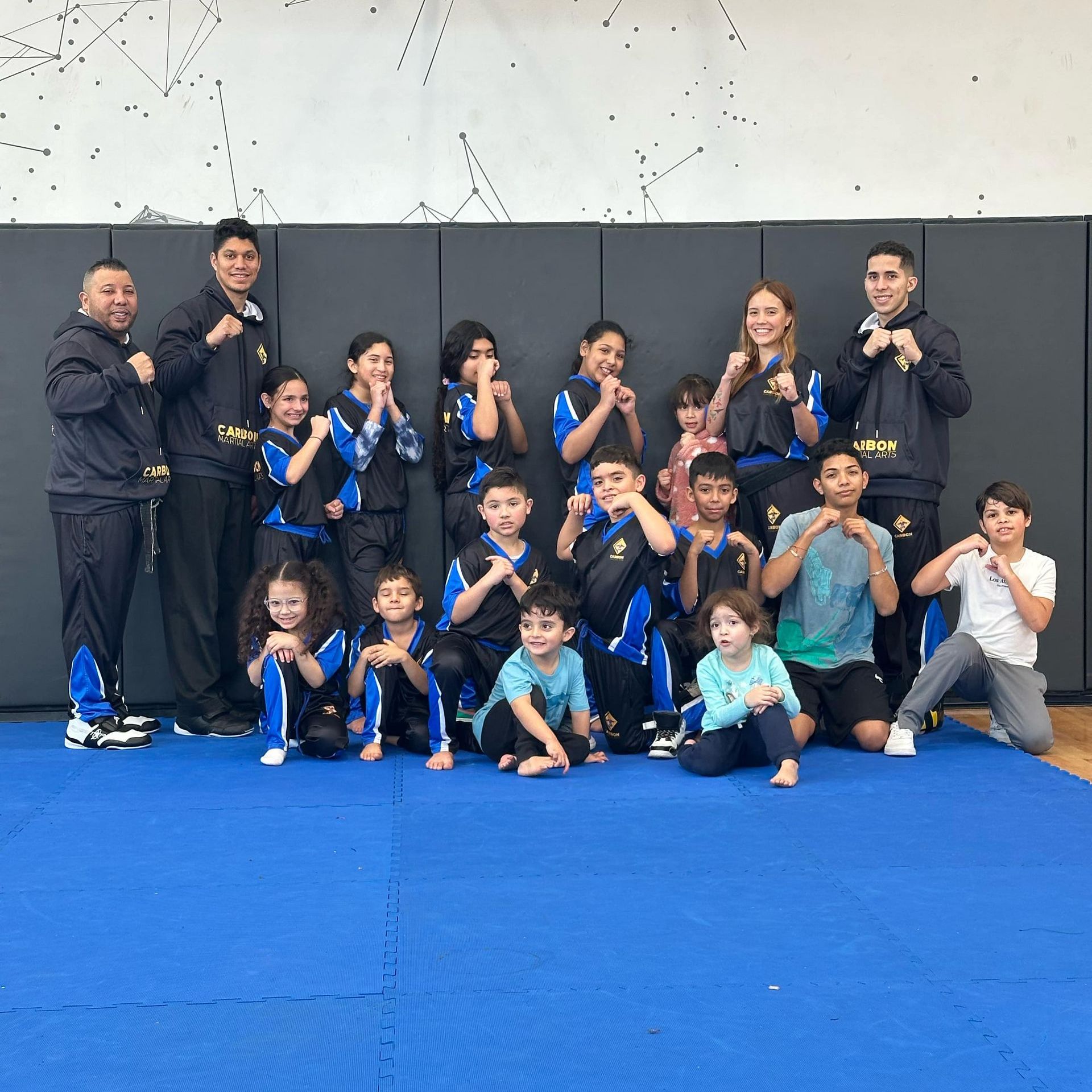 A man and a woman are practicing karate in a gym.