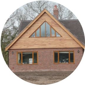 A brick house with a wooden roof and triangle windows