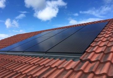 There are solar panels on the roof of a house.