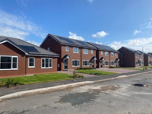 A row of new build brick houses with solar panels on the roofs