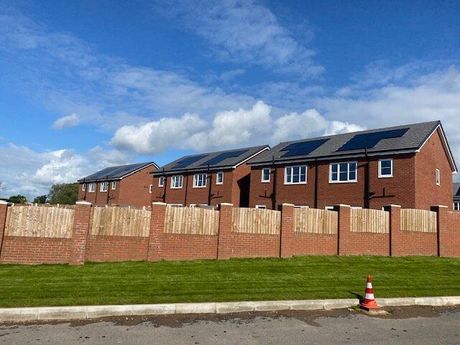 A row of houses with solar panels on the roofs