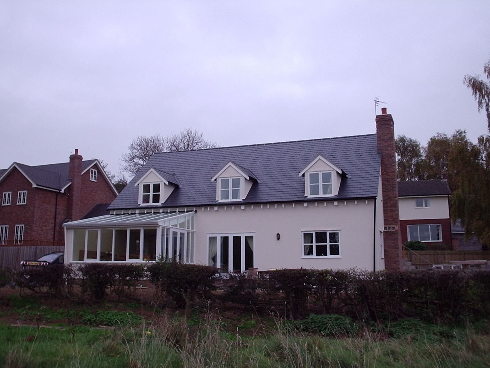 A large white house with a new slate roof, fitted by Nigel Hayman Roofing.