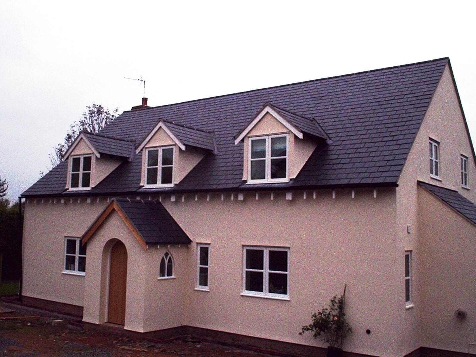 A Pink house with a  new slate roof and white windows