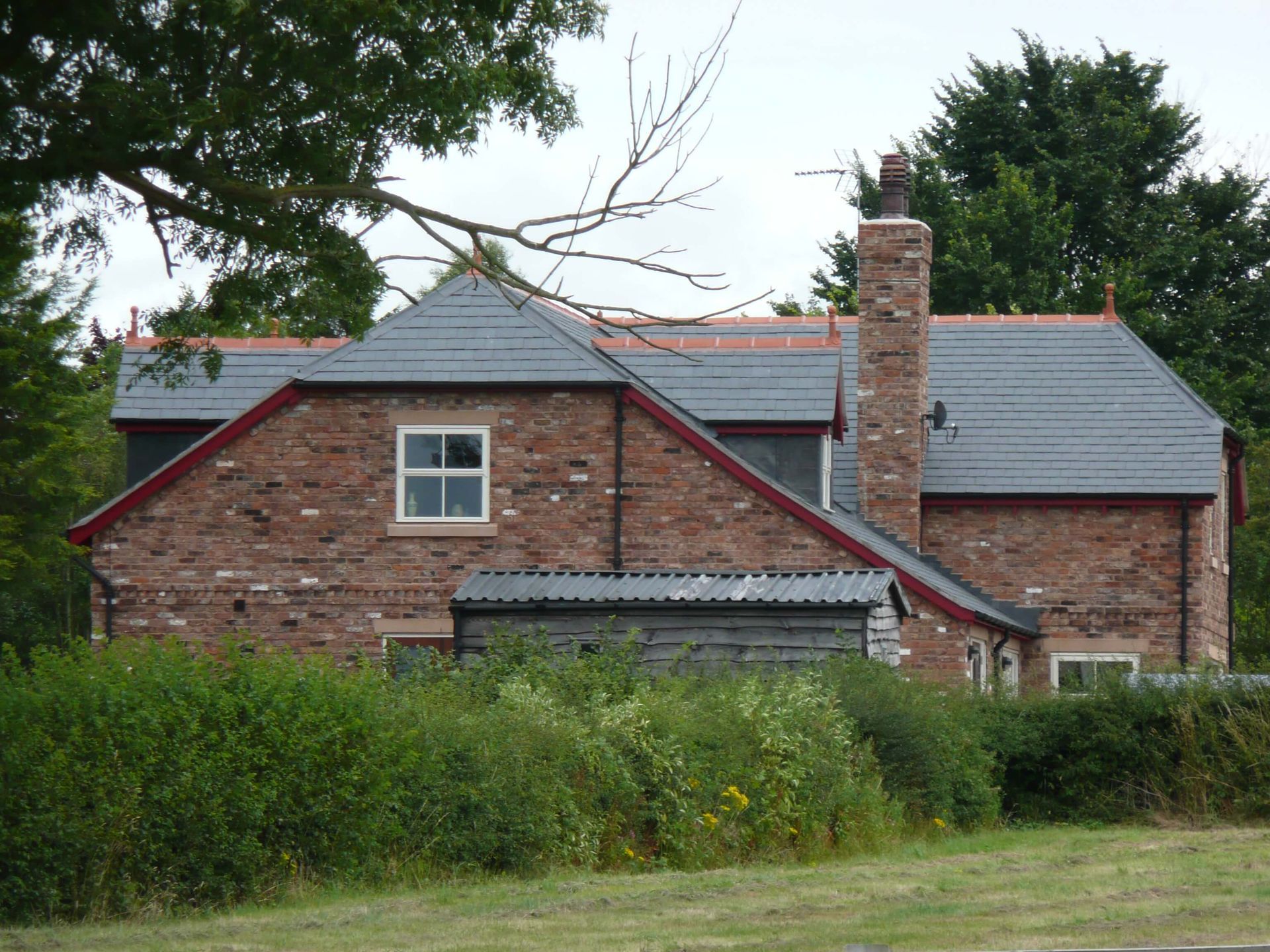 A brick house with a slate roof and a chimney