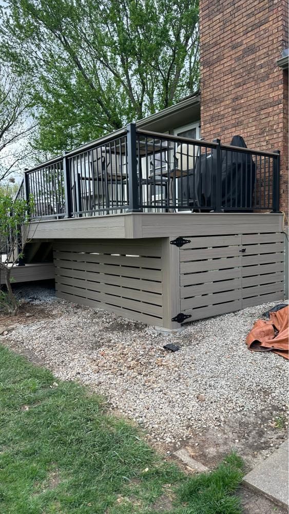 A wooden deck with stairs and a pergola in the backyard of a house.