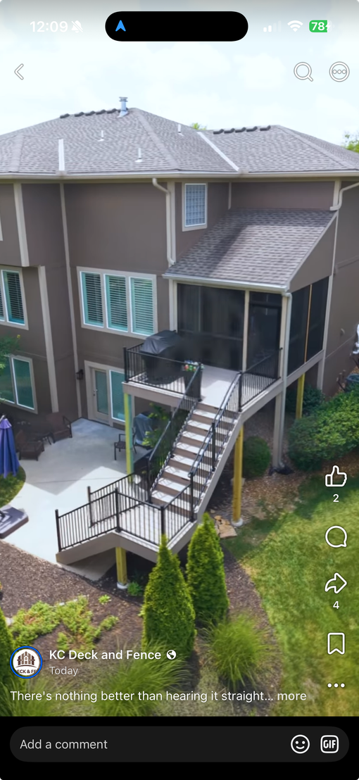 A wooden deck with a metal railing is sitting on top of a house.