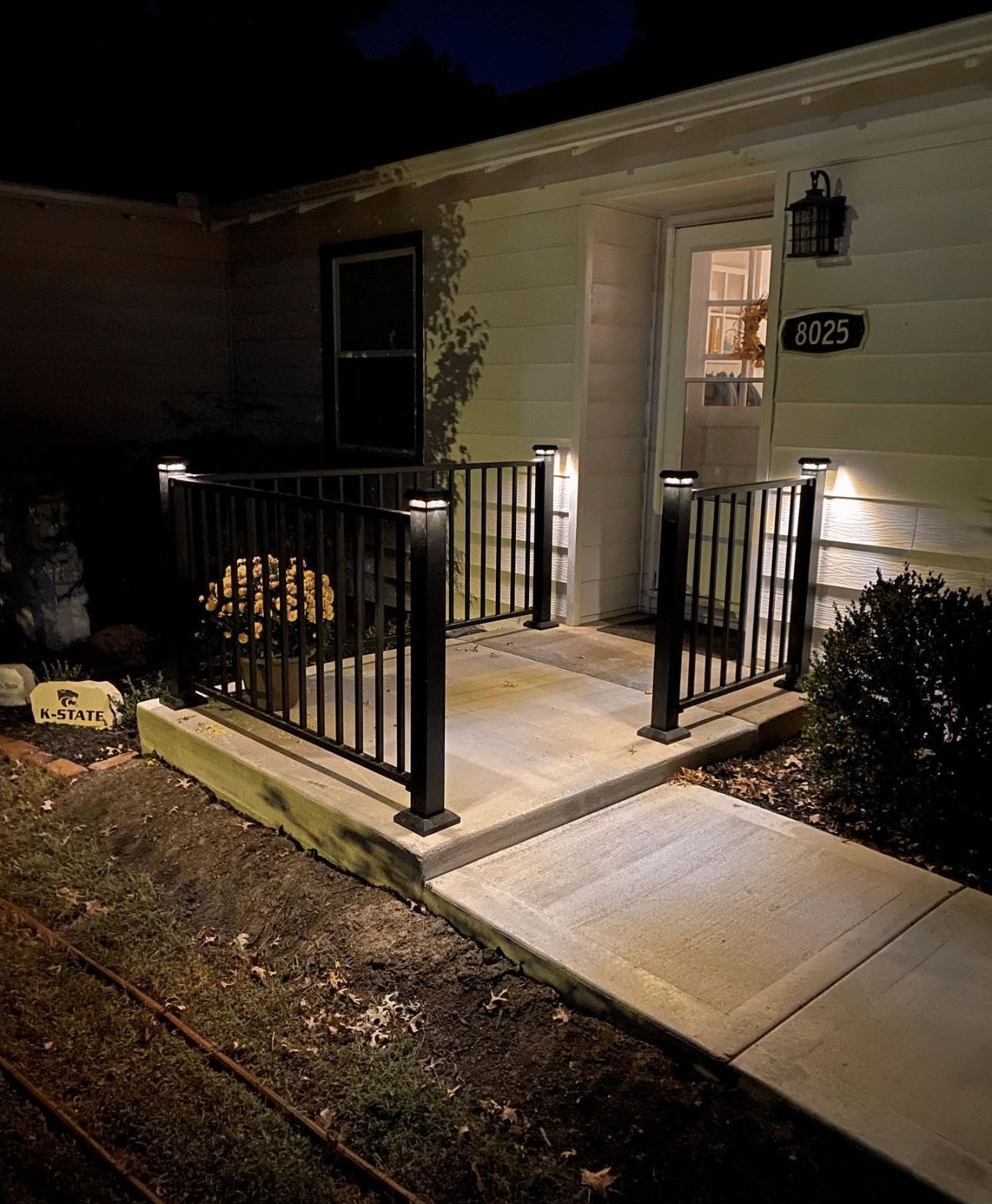 A house with a walkway leading to the front door at night.