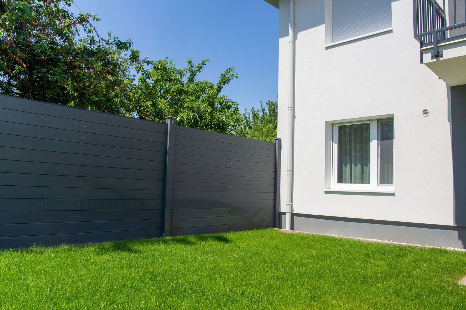 There is a fence in the backyard of a house.