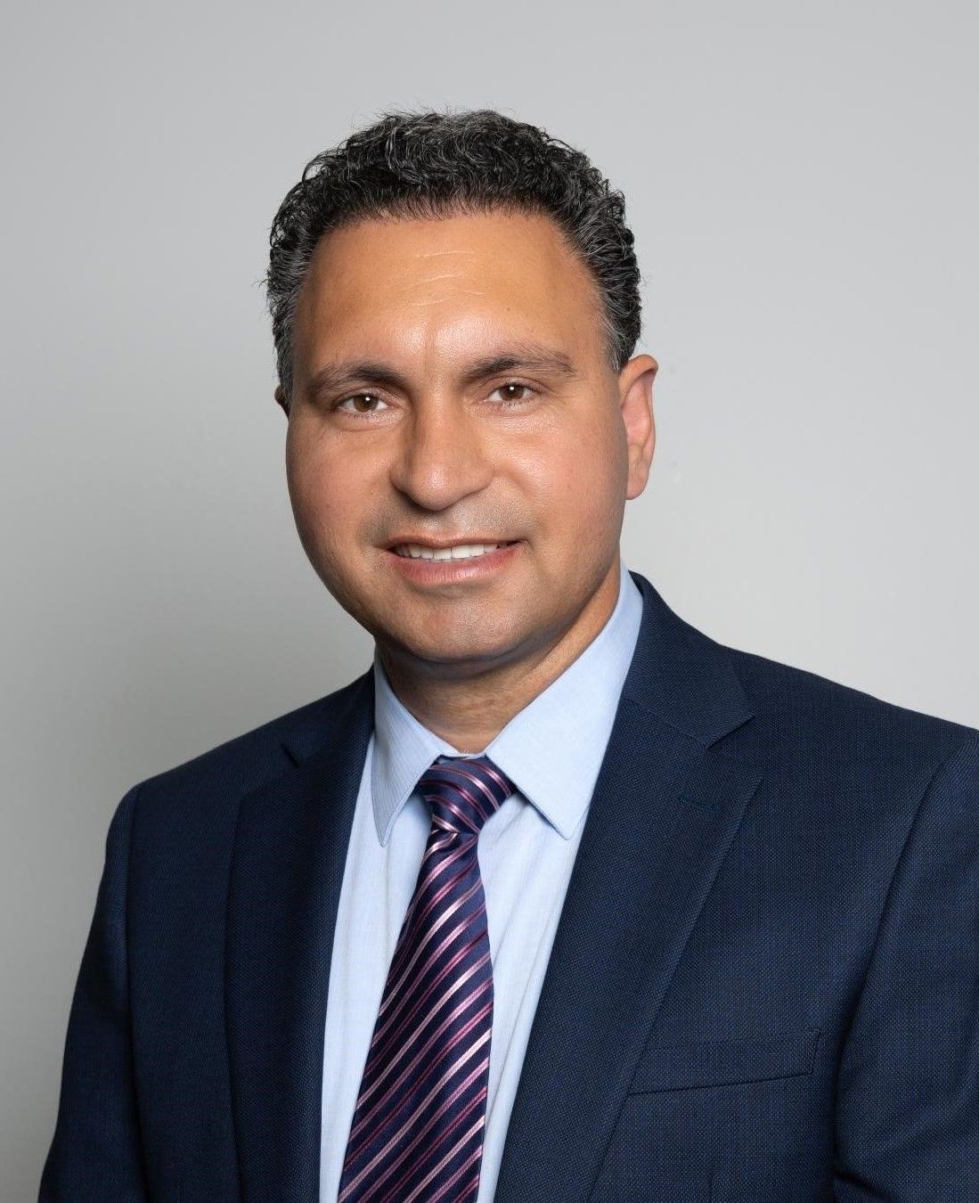A man in a suit and tie is smiling for the camera.