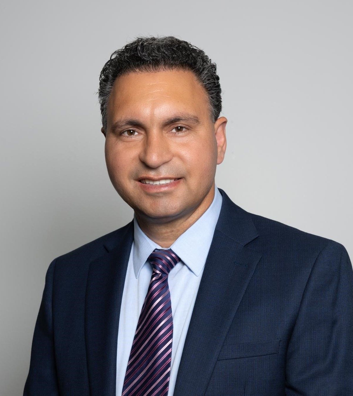 A man in a suit and tie is smiling for the camera.