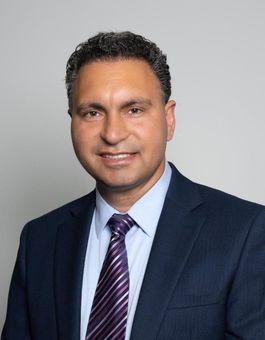 A man in a suit and tie is smiling for the camera.
