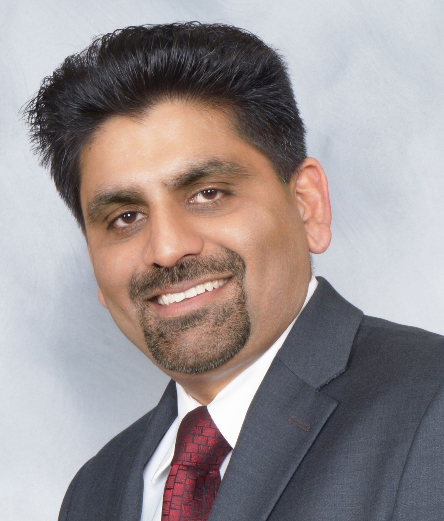 A man in a suit and tie is smiling for the camera
