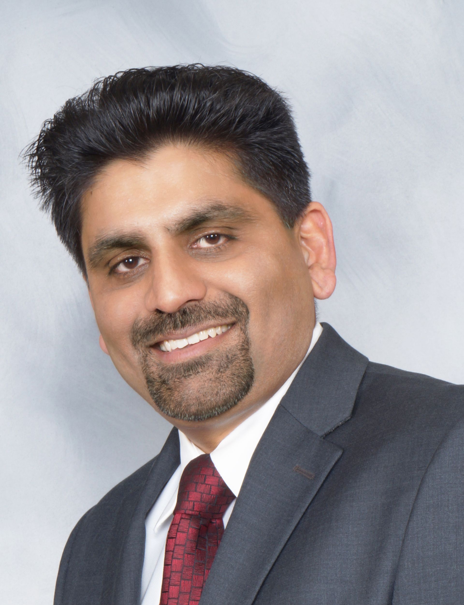 A man in a suit and tie is smiling for the camera