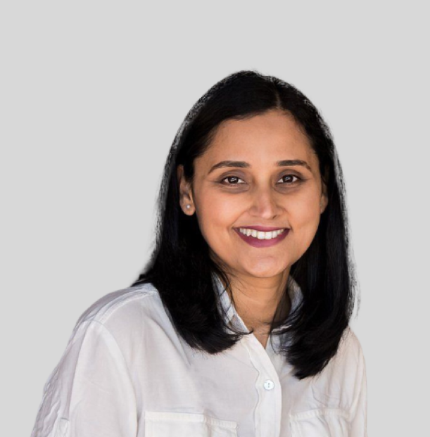 A woman in a white shirt is smiling for the camera