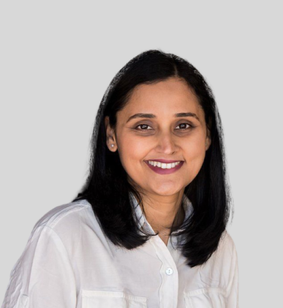 A woman in a white shirt is smiling for the camera