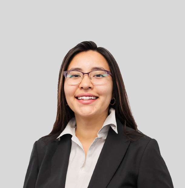 A woman wearing glasses and a black jacket is smiling for the camera.