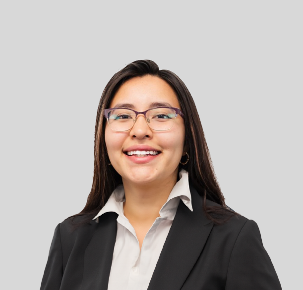 A woman wearing glasses and a black jacket is smiling for the camera.