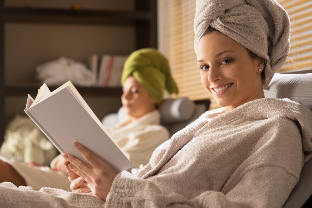 Woman Relaxing At Spa Lying On Sofa And Reading — VR Mobile Beauty Therapy In Oxenford QLD