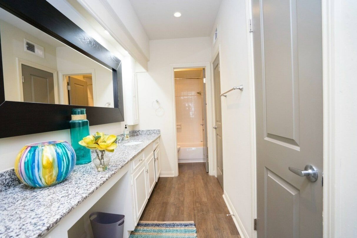 A bathroom with two sinks , a mirror and a trash can.
