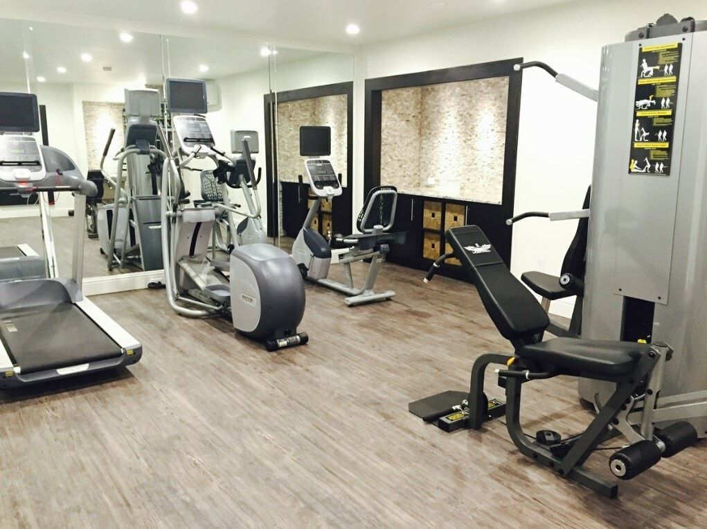 A gym with a lot of exercise equipment and a treadmill.