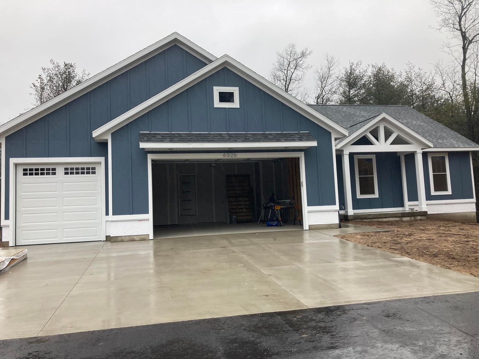 A blue and white house with a garage and a driveway.