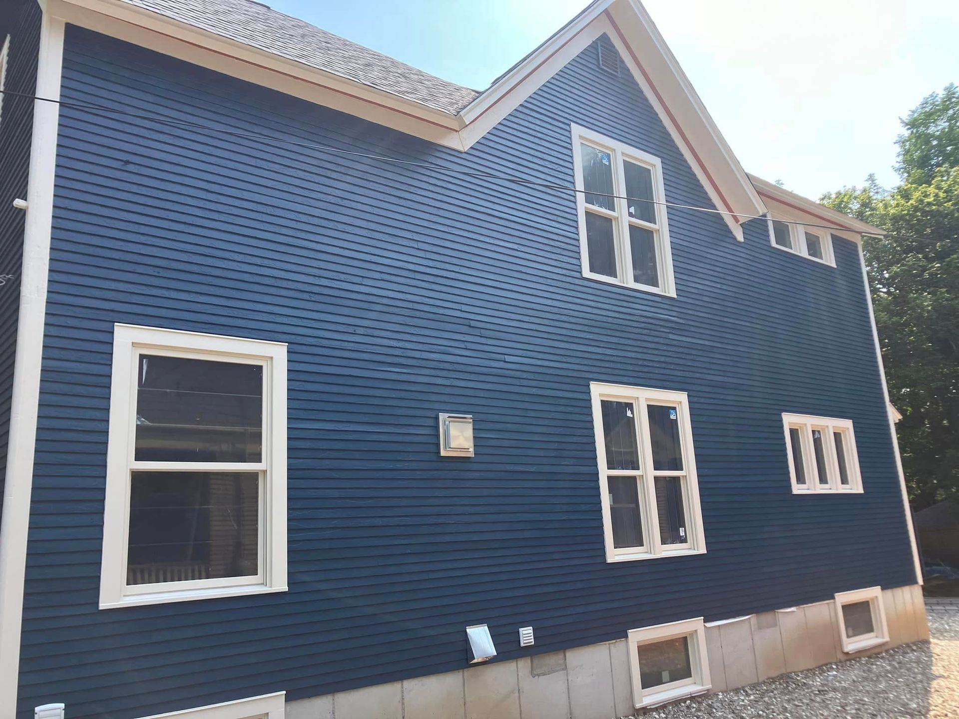 A large blue house with white trim and windows