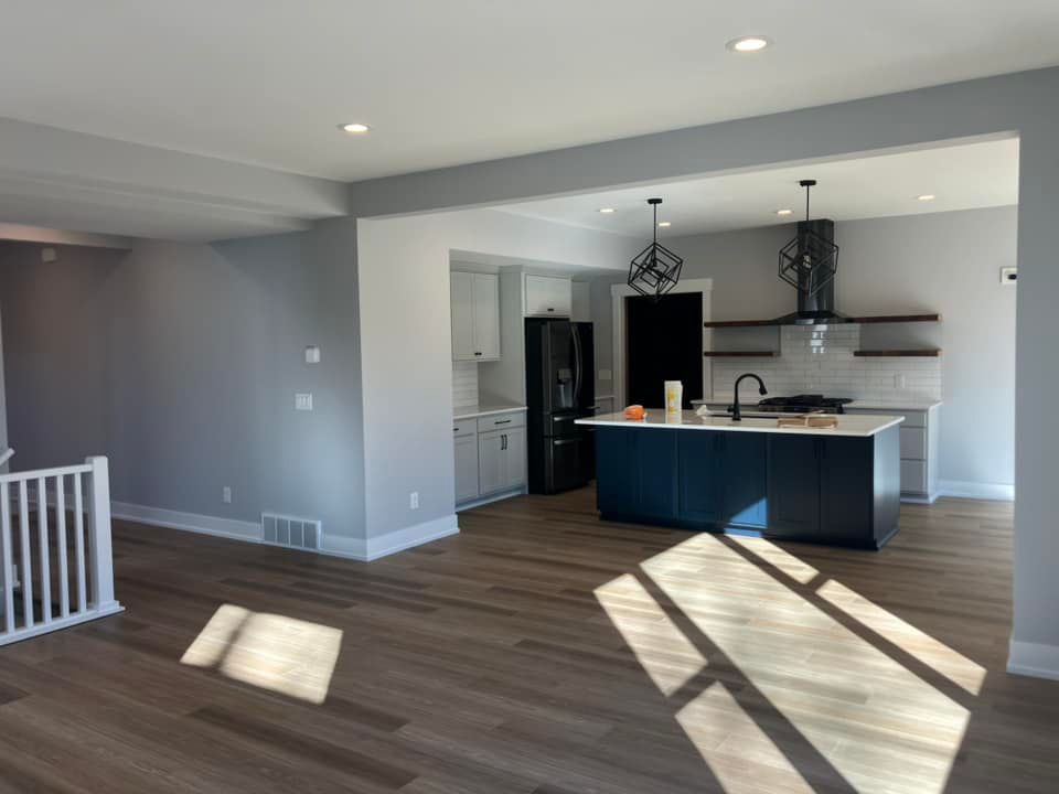 A kitchen with a large island and a refrigerator in a house.