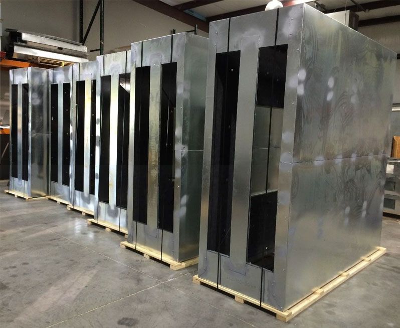 A row of metal boxes sitting on wooden pallets in a warehouse