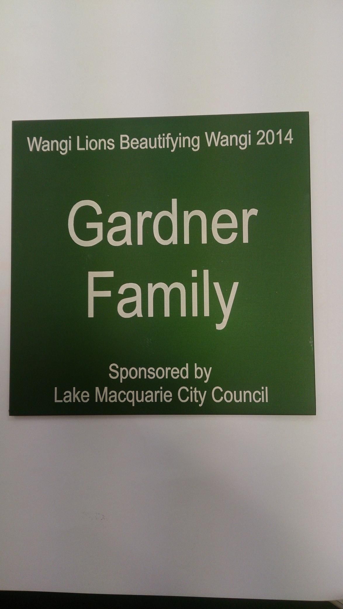 A green sign that says gardner family on it